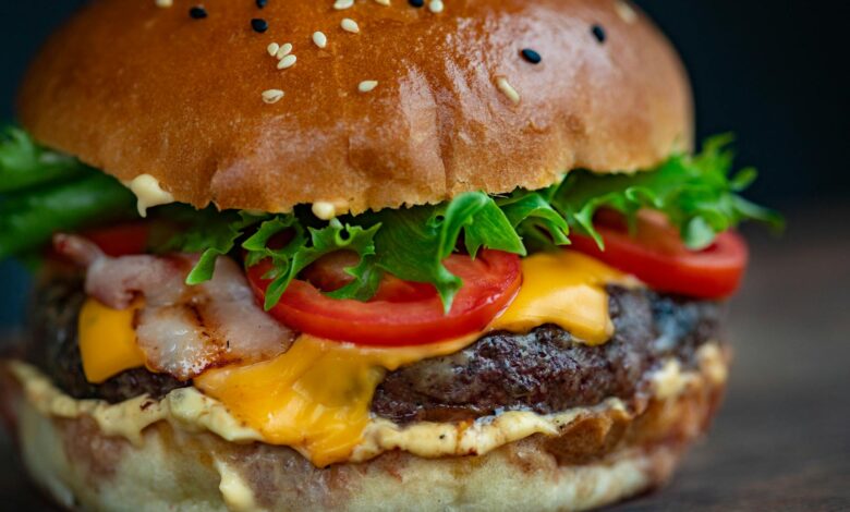 Juicy cheeseburger with bacon, lettuce, tomato, and sesame seed bun.
