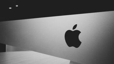 Close-up of a black and white Apple logo on a desktop screen with a modern minimalist design.